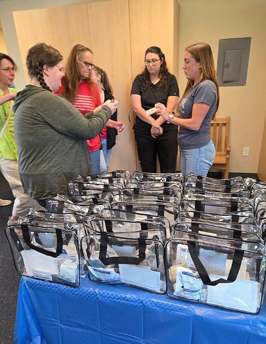 Image of employees standing near a table with care packages