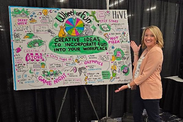 Female at a conference standing next to a vision Board